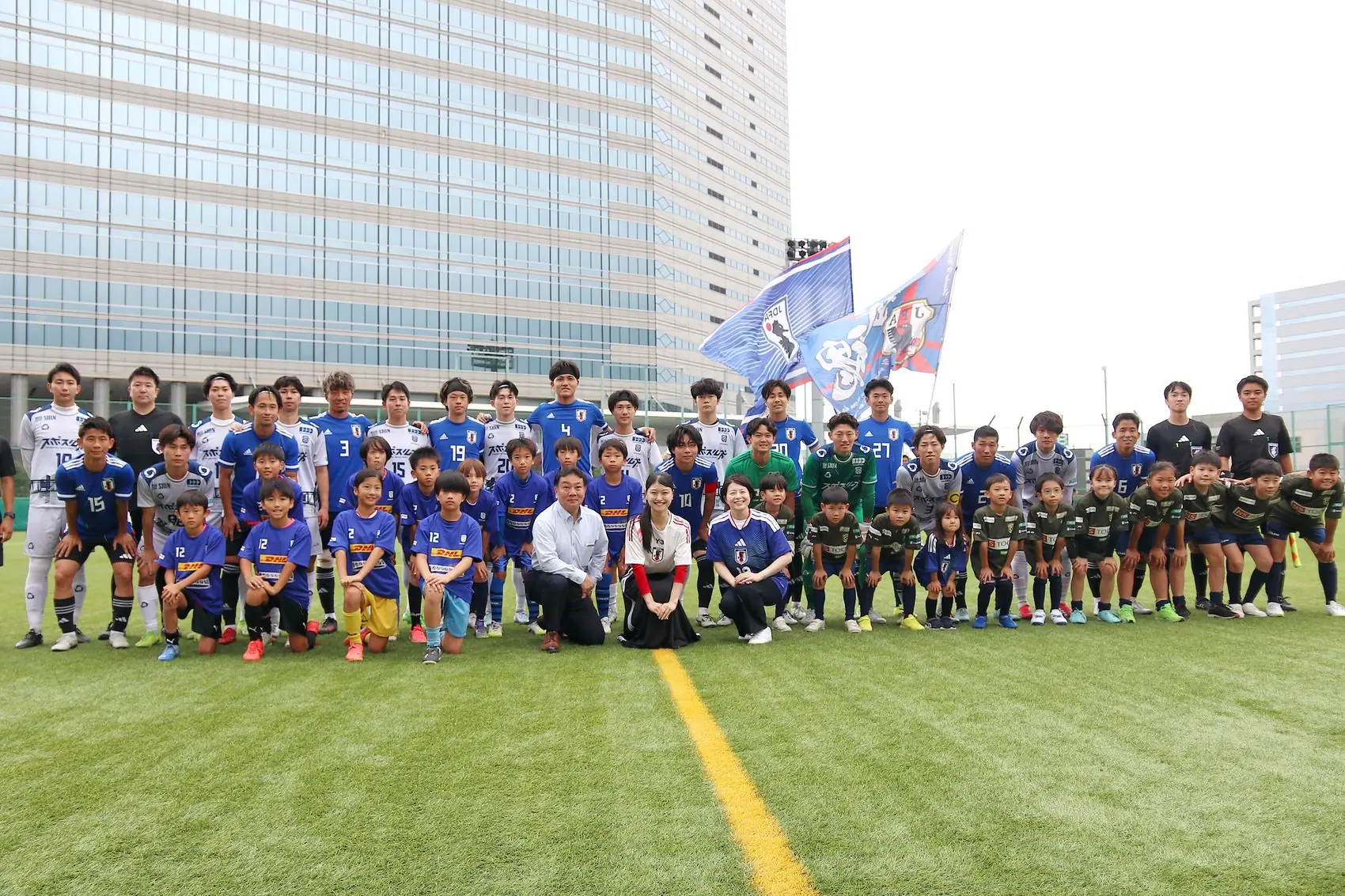 品川の高層ビルを背景にしたサッカーチームの集合写真